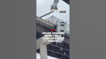 Driver rescued from tractor-trailer dangling over bridge