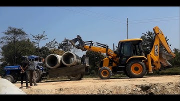 Backhoe Loader Loading Two Pipe Into The Tractor