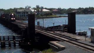 FEC Train 240 with oversized flatcar, generator, and caboose.