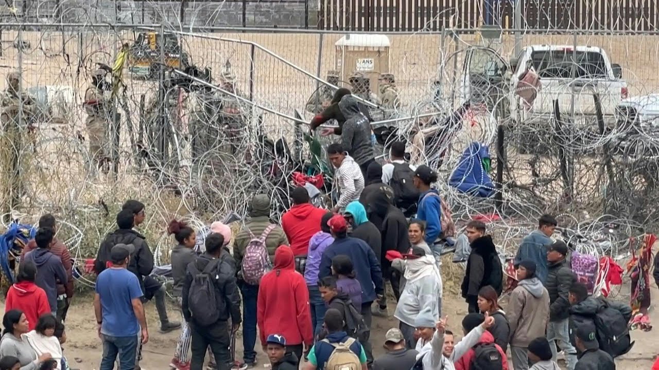 Migrants attempt to pull down section of wire fence on Mexico-US border ...