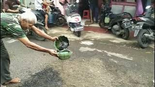 Menutup lubang jalan dengan pasir aspal bekas dan oli bekas
