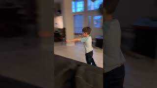 Boy riding blue hoverboard in living room crashes into wall