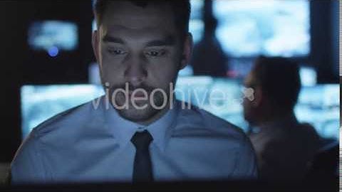 Focused Security Officer is Working on Computer in a Monitoring Room Filled | VideoHive 14742919