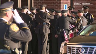 Officers salute Sgt. Brewster's casket as it is brought into church