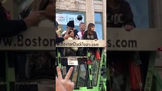 Tom Brady lifting the Lombardi trophy on a duck boat