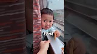 In a train, this little kid kept smiling at a boy sitting