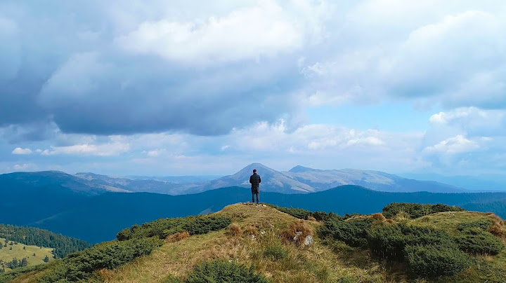 A kid standing on the top of a moutains năm 2024