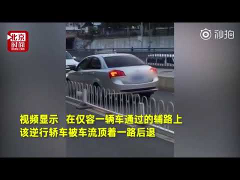 视频：逆行轿车被车流顶着倒退数百米 