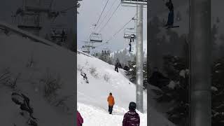 Little boy hanging from and falling off of ski chairlift