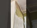 plaster compound to smooth out rough concrete walls using a rectangular trowel during