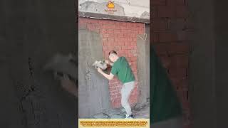Worker Applying Cement Plaster on Brick Wall for Smooth Surface Finishing