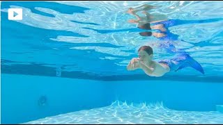 A boy swimming underwater with a mermaid tail