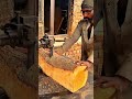 Using a vertical band saw machine to cut and split a large raw log timber in a lumber workshop
