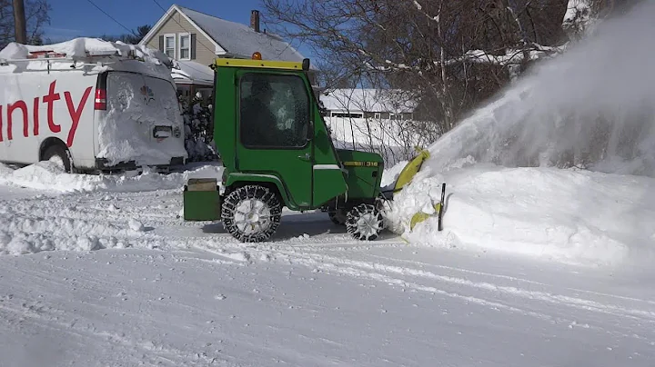 JOHN DEERE 318 WITH 49 SNOWTHROWER MOVING SNOW