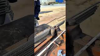 Bending several steel rods manually with a metal machine on a construction site outdoors