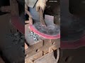 applying wet cement mortar smoothly along the bottom edge of a wall using a hand trowel tool outdoor