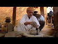 Skilled professional potter throwing the potters wheel and shaping traditional ceramic vessel and