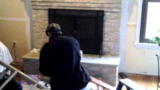 Custom tiling over brick fireplace with granite mantel and hearth.