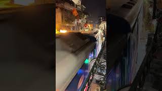 Up-Close View of a Train Passing through a Market during Nighttime