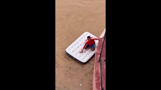 Man rides inflatable mattress through flooded Ibiza