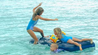 Children playing on the beach with mattress 4k