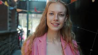 Slow motion portrait of beautiful girl with blond hair standing outside in city street