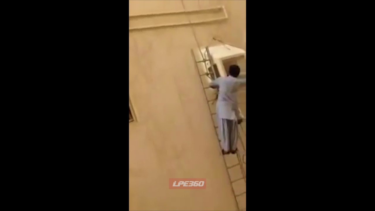 Man on tall ladder fixing air conditioner