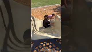 Little boy goes down slide at playground then bumps his face on edge of slide