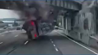 Live Semi truck slams into a highway overpass, shearing off part of its trailer Station Image