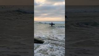 Surfer heads out at sunset