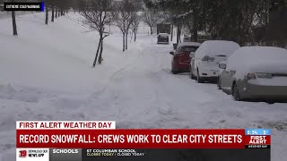 Crews work to clear city streets from record snowfall
