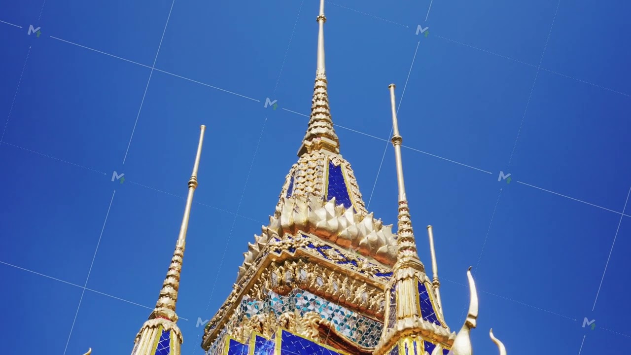 Exquisite architectural details of the golden roof of a temple in the Grand Palace against a clear