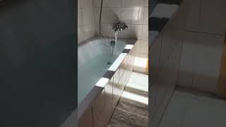 Running a hot bath in a sunny bathroom