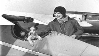 A young woman pulls a tiny biplane, loads her baggage and flies the biplane in Li...HD Stock Footage