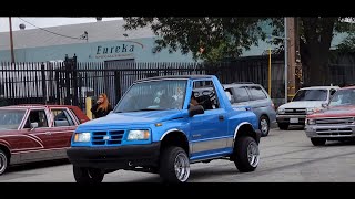 lowriders cruising on a cloudy day and a little bit of rain