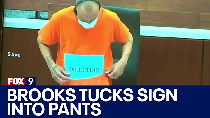 Darrell Brooks tucks his objection sign into pants...