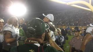 USF coach Skip Holtz hugs players on field after Notre Dame win