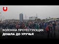 Колонна протестующих идет по дождем на Уручье