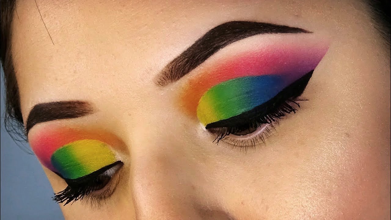 Una donna con un trucco colorato e un trucco per gli occhi arcobaleno.