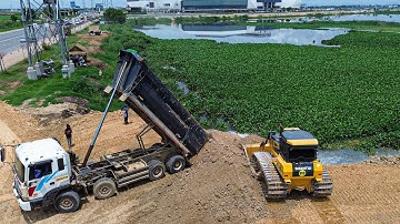 Nice video bulldozer pushing soil filling up land with dump trucks 