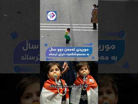 مورید تەمەنی دوو ساڵە و بە مەمەوشکە و ئاڵای کوردستان بە ڕێ پێوان بەناو خۆپیشاندەراندا دەڕوات