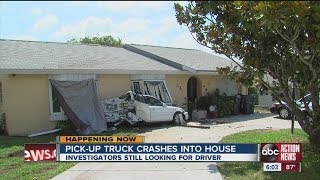 Pickup truck crashes into house