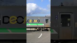 真直ぐな道とDecmo（JR北海道H100形）が走る　根室本線踏切にて