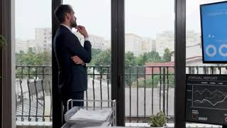 businessman in formal suit sitting near the windows of his office in rainy day zoom in slow motion s screenshot 2