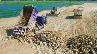 Good Operation add layer of rock on the sand to create new road dozer push rock, truck unload stones