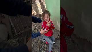 Kid jumps towards black and white goat then trips and bumps head on wall