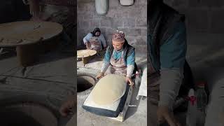 Baking the first Lavash bread in the traditional oven-tonir