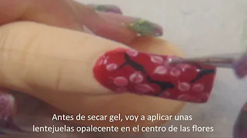 Tutorial de uñas con esmalte rojo y con flores de cereza blancas rosa