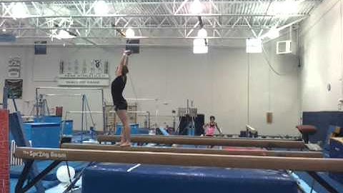 Back handspring layout stepout on high beam.