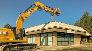 Caterpillar excavator wrecking and Hauling away a thrift shop